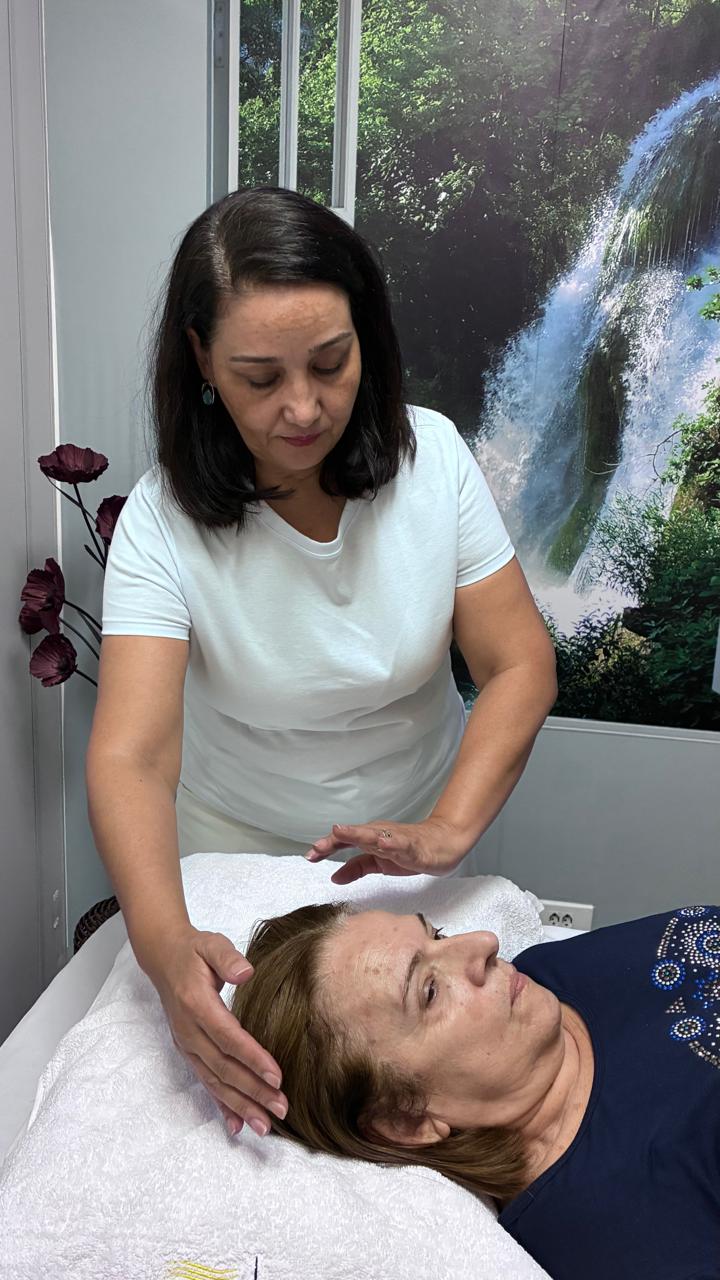 Adriana aplicando Reiki durante atendimento